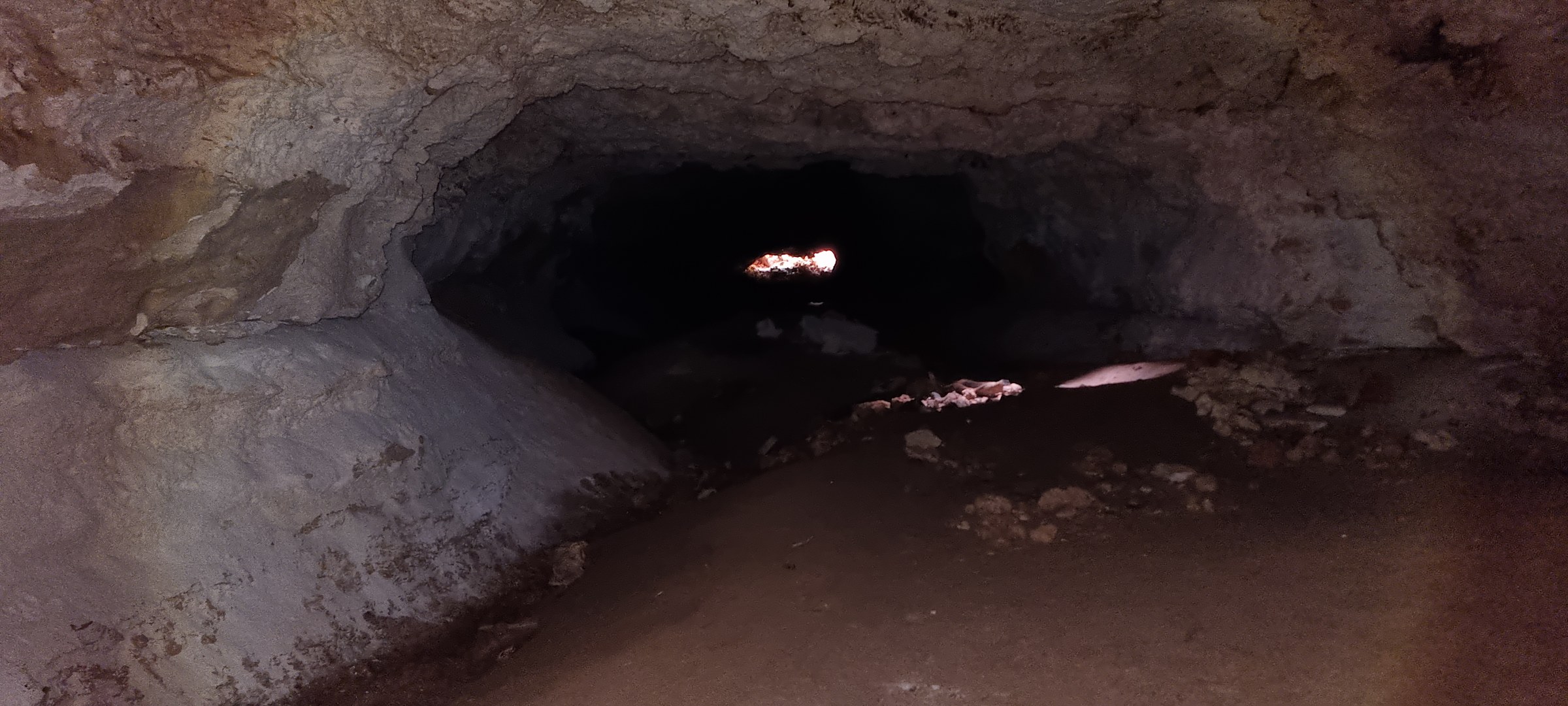 Looking outward from inside the limestone tunnel entrance back toward the morning daylight